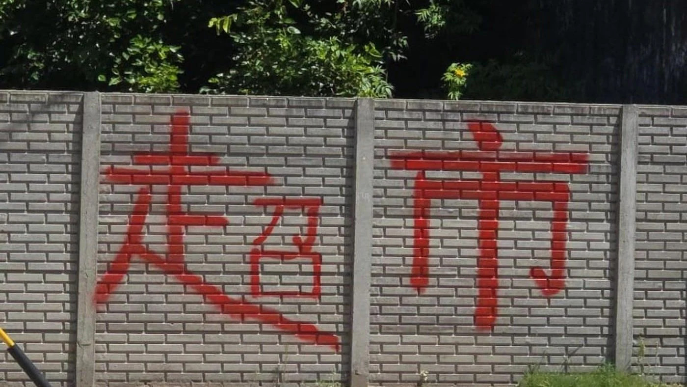 Muro de un terreno céntrico de San Cristóbal con caracteres chinos pintados en rojo, que despertaron rumores